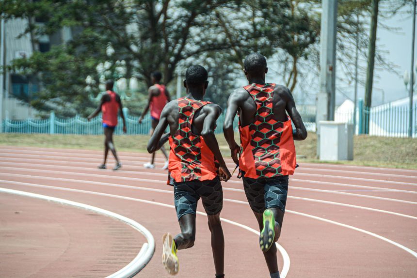 Dois atletas correm lado a lado em uma pista de atletismo em Nairóbi, no Quênia.
