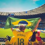 Torcedores brasileiros seguram uma bandeira nas arquibancadas durante uma partida de futebol