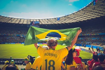 Torcedores brasileiros seguram uma bandeira nas arquibancadas durante uma partida de futebol