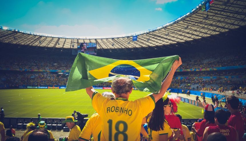 Torcedores brasileiros seguram uma bandeira nas arquibancadas durante uma partida de futebol
