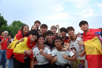 Torcedores exibem bandeiras da Espanha e vestem camisas da seleção durante uma celebração ao ar livre em Madri.