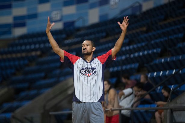 Árbitro sinaliza durante uma partida de basquete em uma arena coberta.