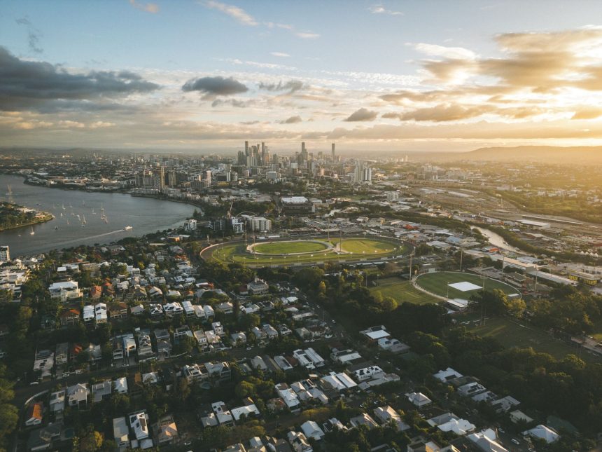 Vista aérea de Brisbane ao pôr do sol, com o rio e o horizonte urbano da cidade australiana.