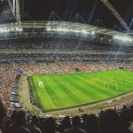 Arquibancadas de um estádio de futebol lotadas de torcedores durante uma partida.
