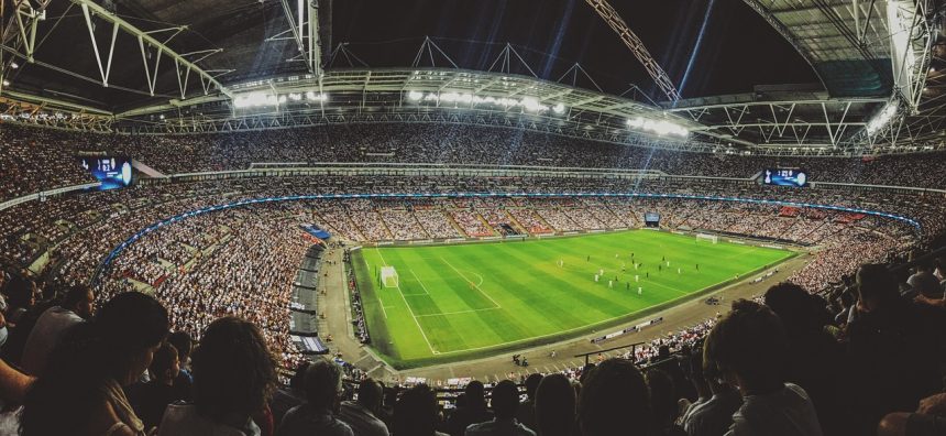 Arquibancadas de um estádio de futebol lotadas de torcedores durante uma partida.